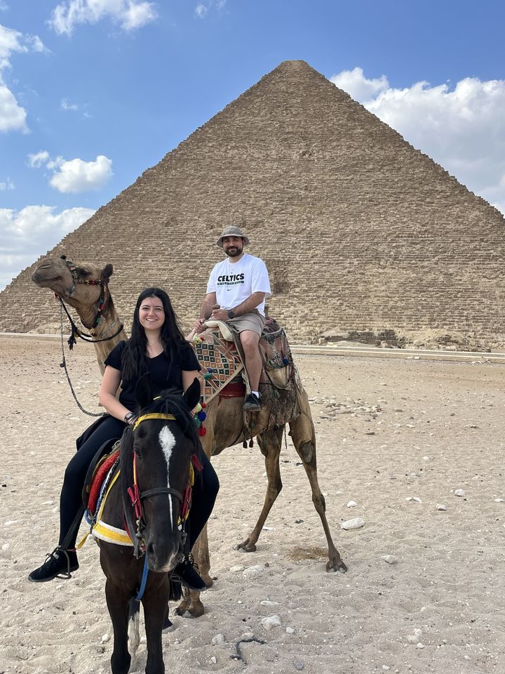 Jessica on horseback and Rami on a camel at the Great Pyramid of Giza