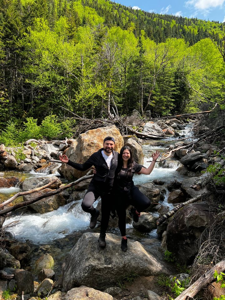 Jessica and Rami on the rocks of a rushing forest stream