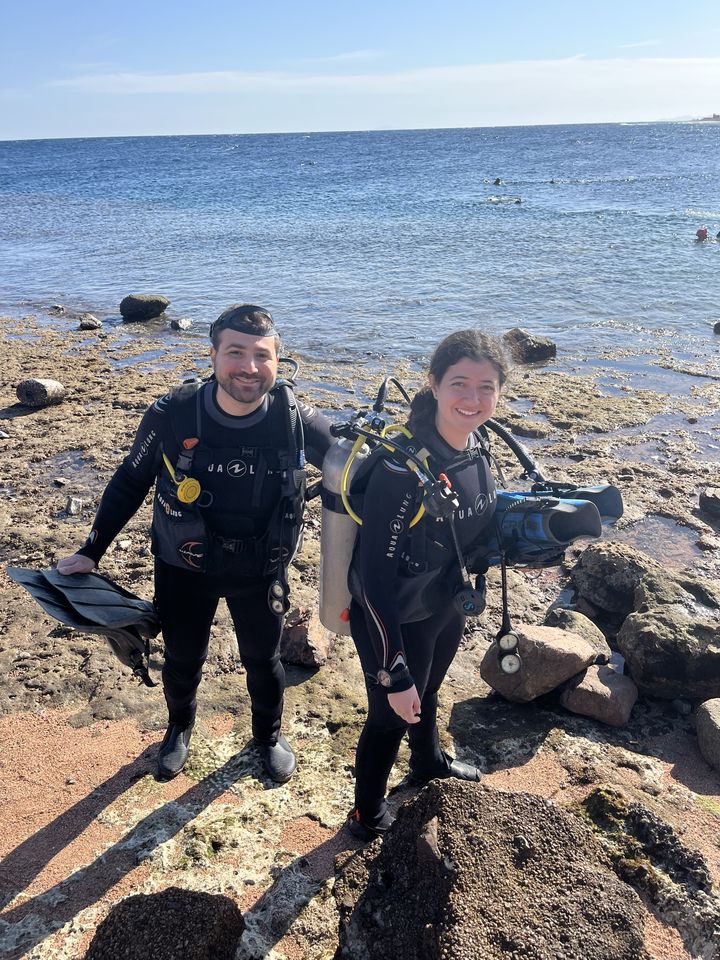 Jessica and Rami in scuba gear by the sea