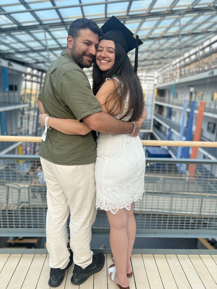 Jessica in her graduation cap hugging Rami