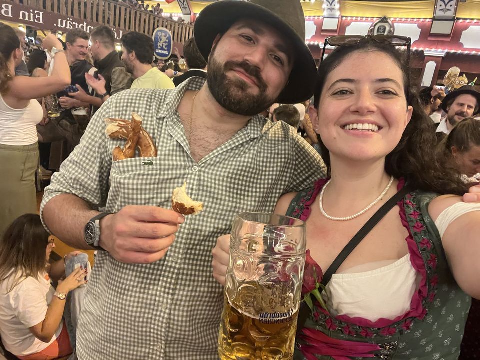 Jessica and Rami at Oktoberfest with a pretzel and a beer stein