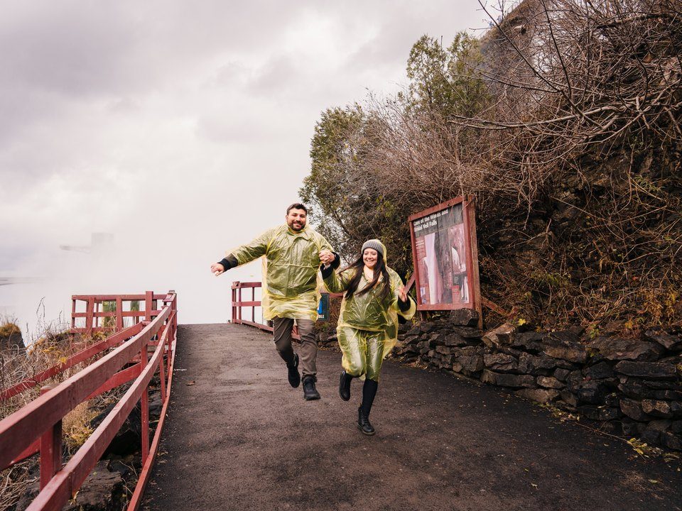 Jessica and Rami running in rain ponchos at Niagara Falls