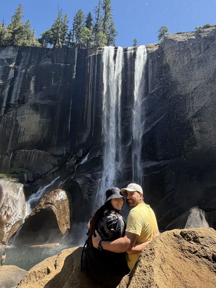 Jessica and Rami in front of a tall waterfall